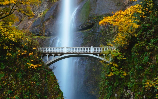 a bridge with a waterfall behind it