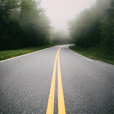 a foggy highway with painted yellow dividers